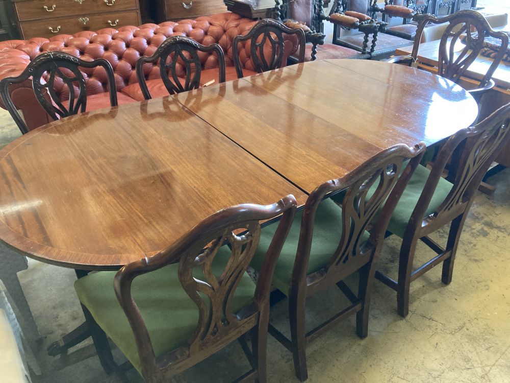 A set of seven George III style mahogany dining chairs (one with arms) together with a mahogany twin pillar extending dining table, 208